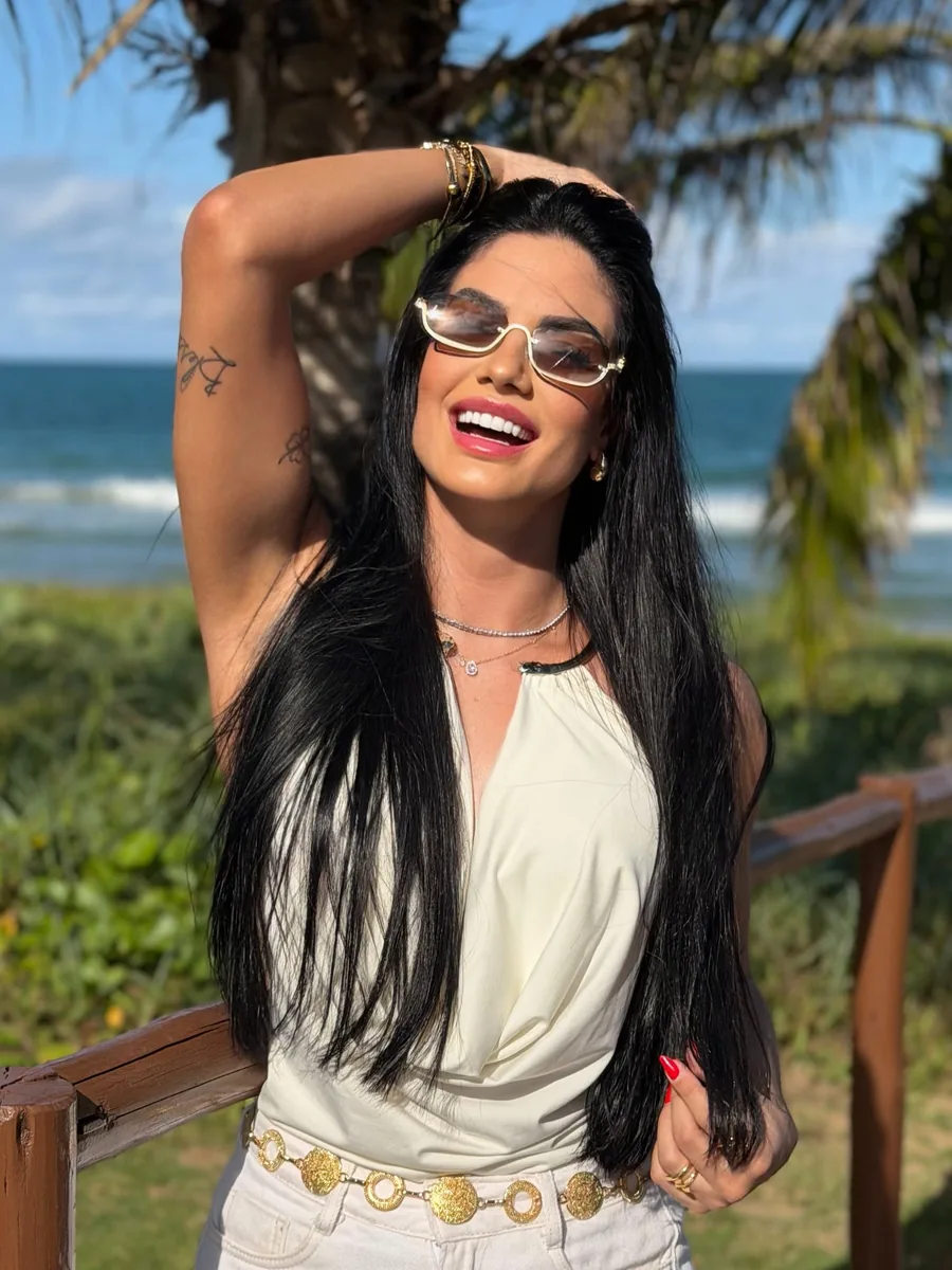 Victória Andrade sorrindo em um cenário de praia
